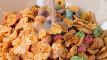 A bowl of cereal with milk being poured.
