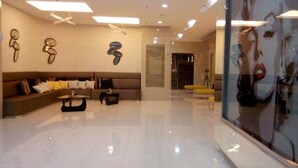 A modern living room with a sofa, coffee table, and decorative wall art. - M Place at Abs by Noemi (Quezon City)