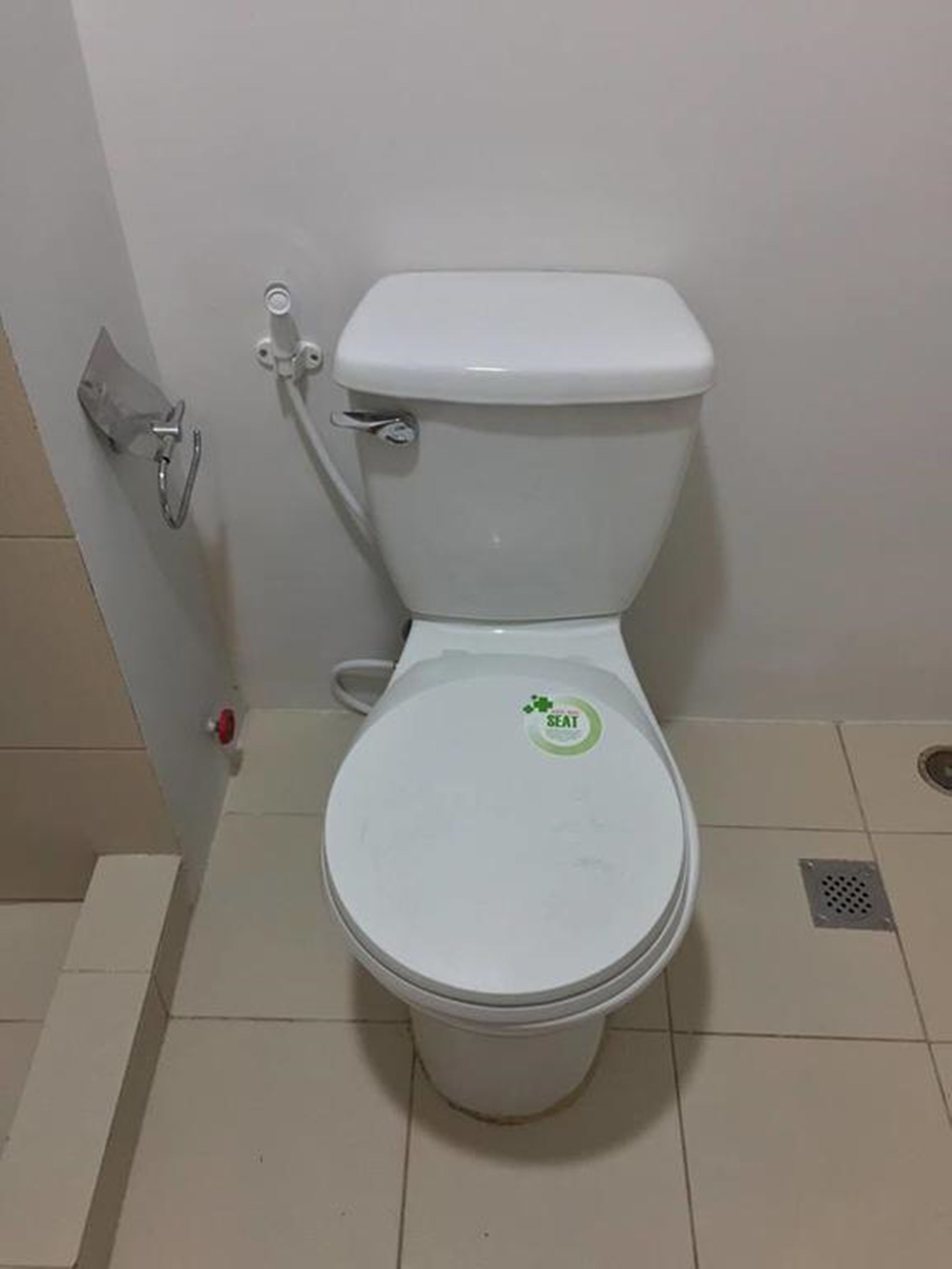 Des toilettes avec un abattant et une poignée de chasse d'eau.