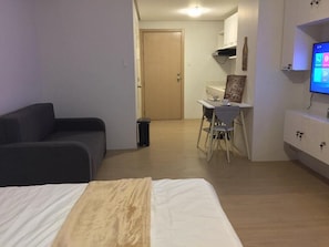 A bedroom with a bed, a desk, and a chair. - M Place at Abs by Noemi (Quezon City)
