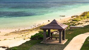 A gazebo with a tiled roof overlooking a beach with clear turquoise water. - Xiang xie Homestay (Baisha)