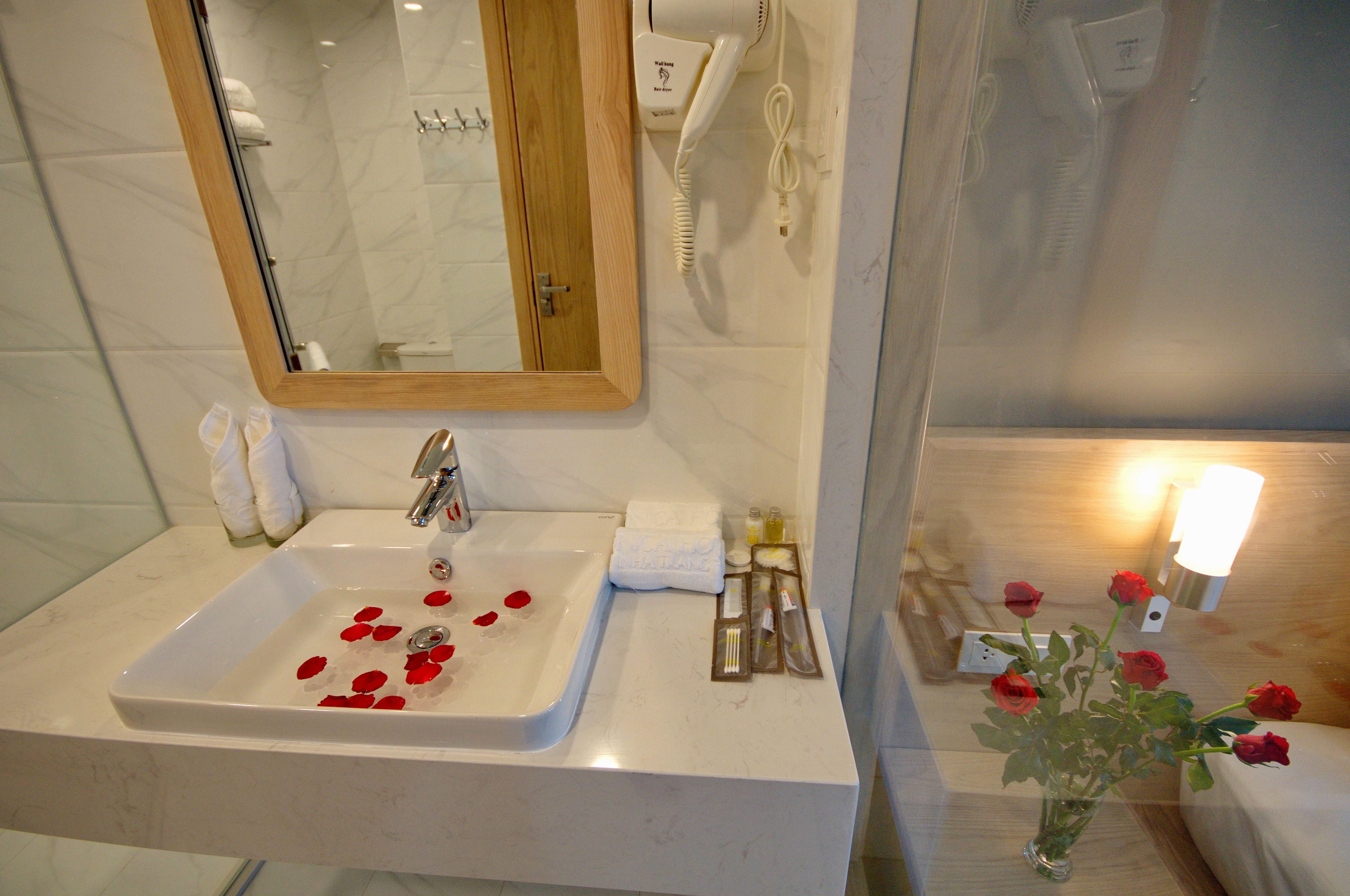 A bathroom with a sink, mirror, and toiletries.