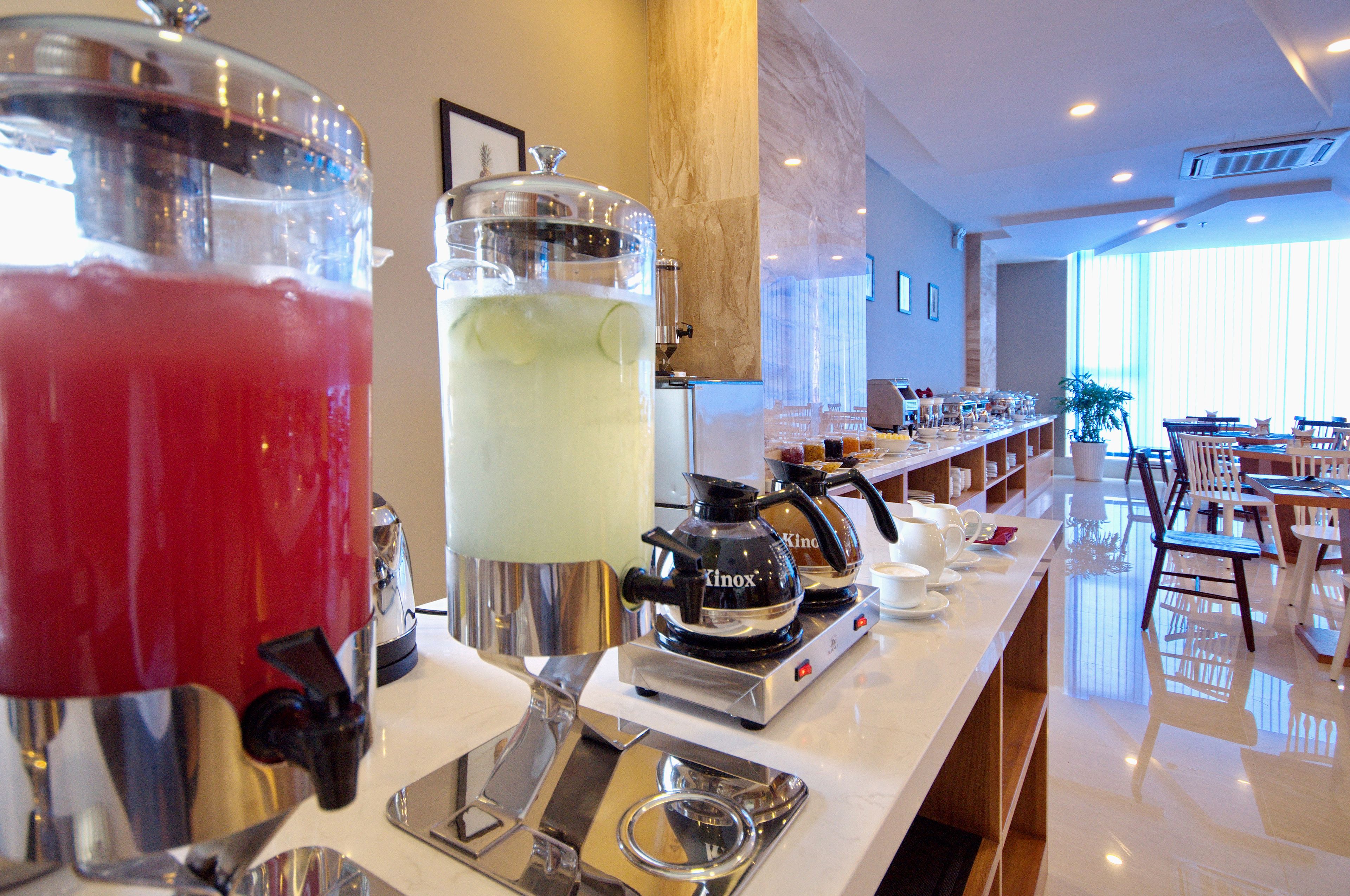 A bar area with a coffee machine and a large pitcher of iced tea.