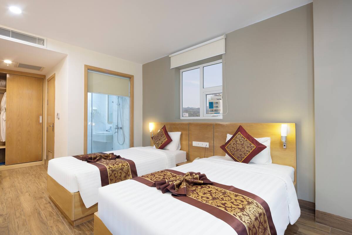 Une chambre d’hôtel avec deux lits, un espace douche et une vue sur la ville.