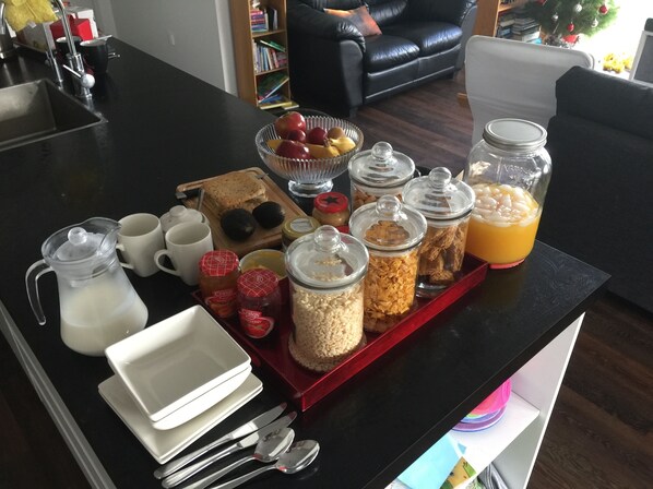 Buffet de café da manhã com diversos alimentos e bebidas em uma bandeja.