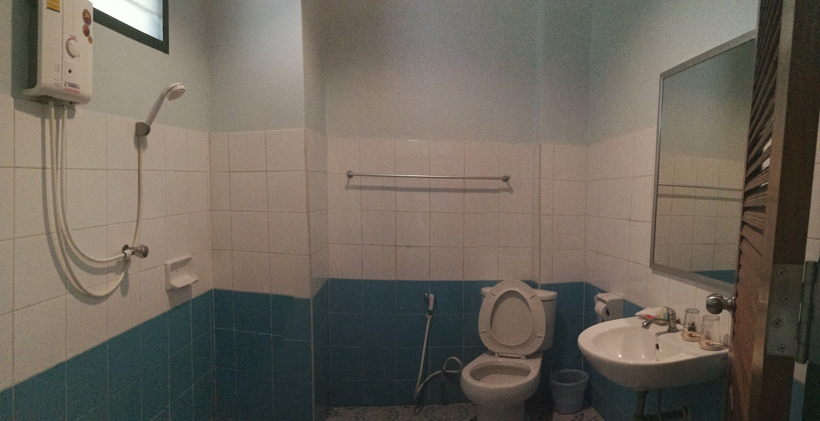 A bathroom with a toilet, sink, and shower.