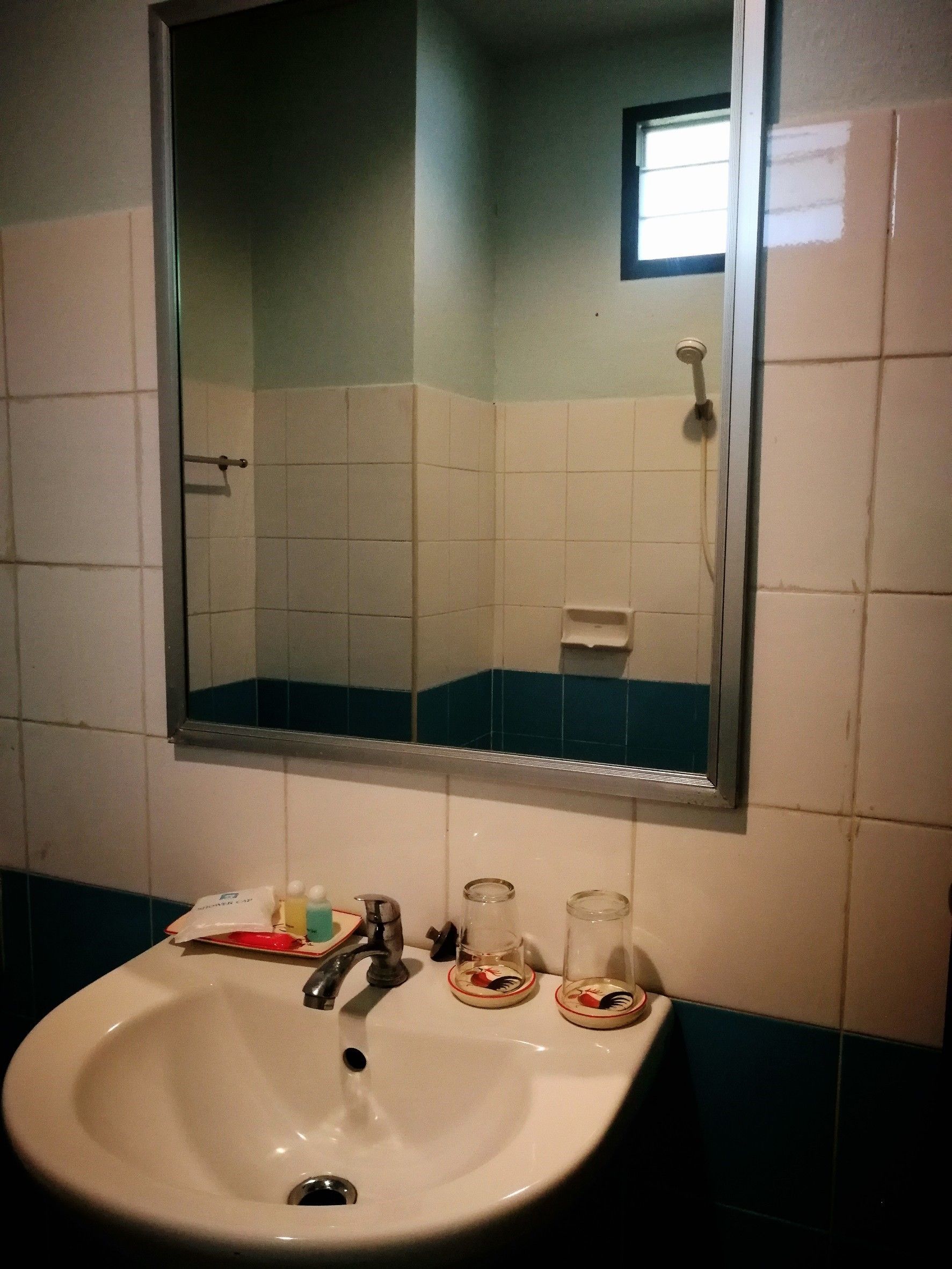 A bathroom with a white sink, a mirror, and a shower.