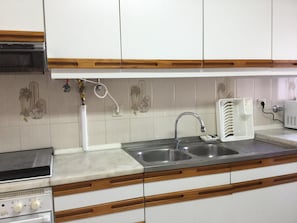 A kitchen with a double sink, a white toaster, and a stove. - APARTMENT LISBON - REBOLEIRA (metro / train) (Amadora)