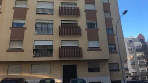 A multi-story building with balconies, windows with shutters, and a clear sky. - APARTMENT LISBON - REBOLEIRA (metro / train) (Amadora)