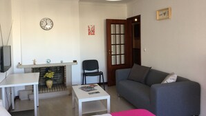 A living room with a fireplace, a sofa, a coffee table, and a TV. - APARTMENT LISBON - REBOLEIRA (metro / train) (Amadora)