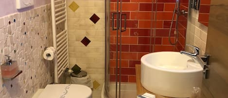 A bathroom with two sinks, a shower, and a toilet.
