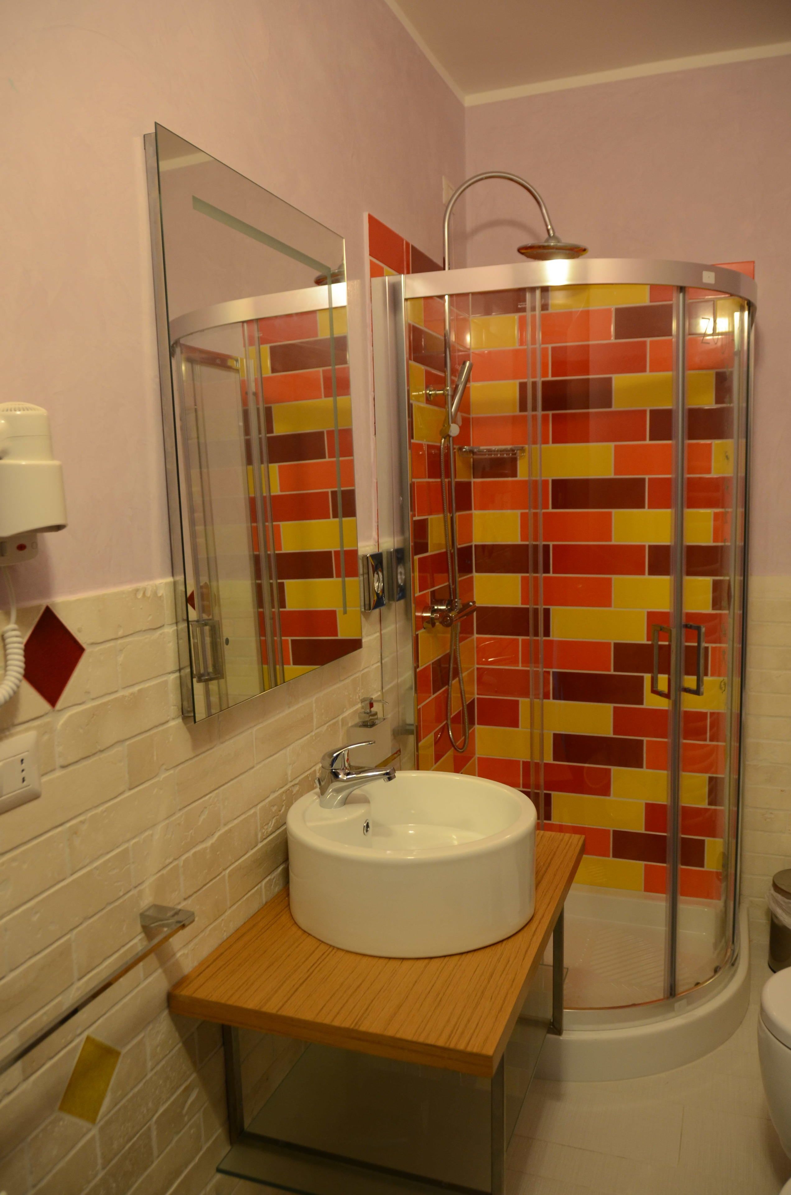 Une salle de bain avec une douche à parois de verre, un lavabo blanc et un miroir.