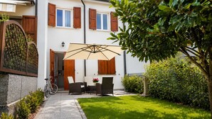 A house with a patio, a bicycle, and a garden.