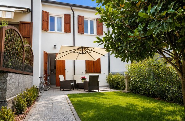 Una casa con patio, bicicleta y jardín.