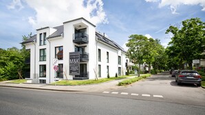 Un edificio moderno con un letrero que dice 'Boardinghouse by M&K'.