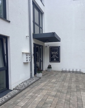 A modern building with a clean facade, large windows, and a signboard. - Boardinghouse by M&K (Bad Oeynhausen)