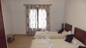 A hotel room with two beds, each with a swan-shaped towel, a wooden headboard, and a bedside table with a lamp. - EXCLUSIVE VILLA WITH PRIVATE POOL, JUST 1 MINUTE FROM CALÓ DES POU BEACH (Cala D'or/Santanyi)