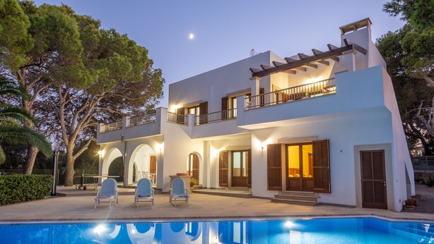 A modern two-story house with a swimming pool, outdoor seating, and a balcony. - EXCLUSIVE VILLA WITH PRIVATE POOL, JUST 1 MINUTE FROM CALÓ DES POU BEACH (Cala D'or/Santanyi)