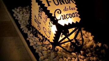 A sign with the text 'FONDA de las Cucas' illuminated by lights.