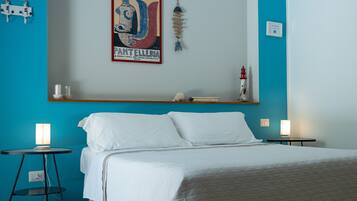 A bedroom with a bed, two bedside tables, a wall-mounted shelf, and a decorative item.