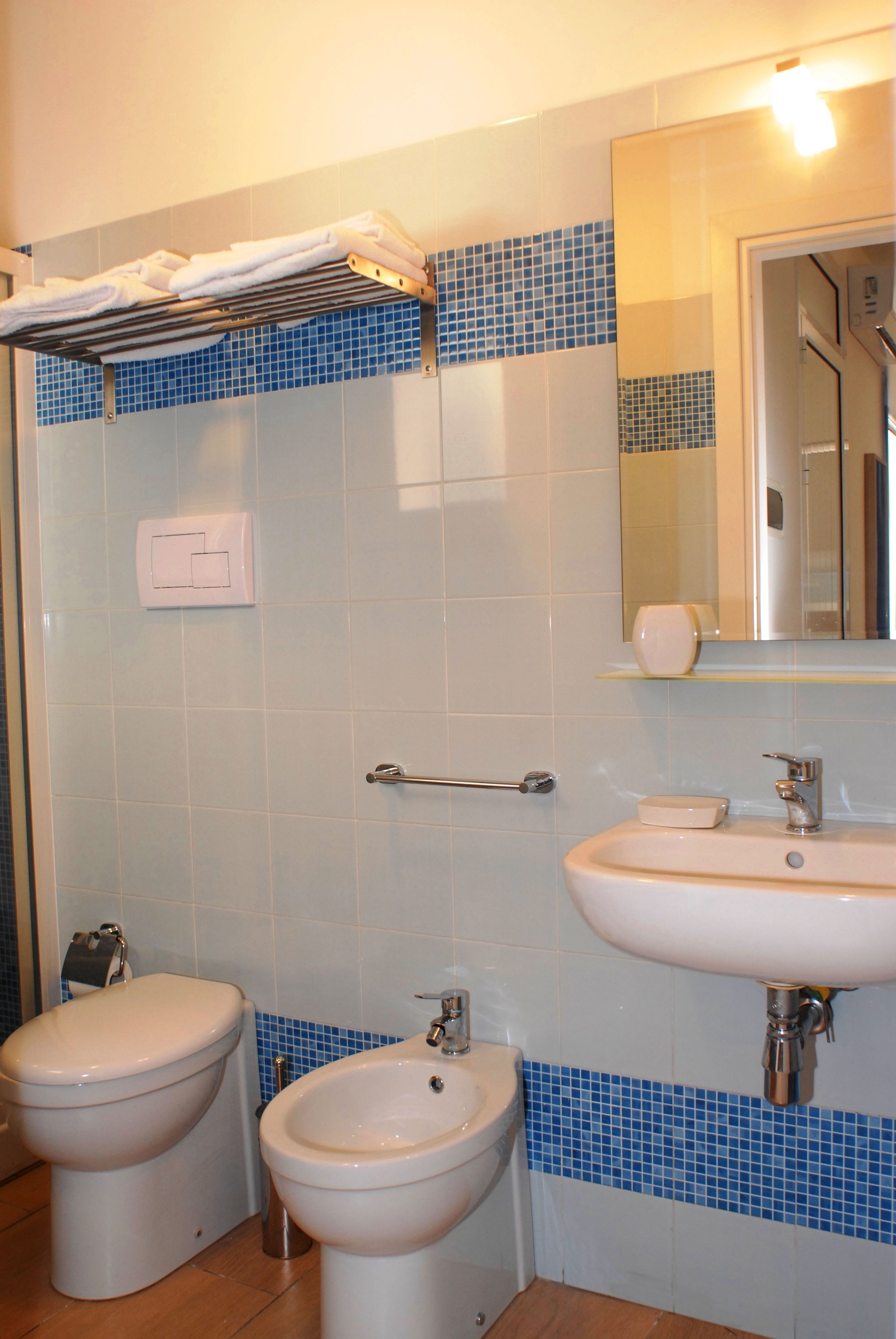 Ein Badezimmer mit Bidet, Waschbecken und Spiegel.