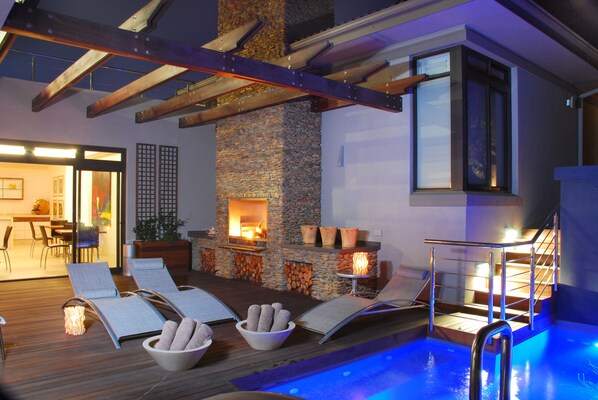 Una piscina al aire libre, sombrillas, sillones reclinables de piscina