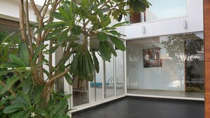 Une maison moderne avec une porte en verre donnant sur un patio sombre.
