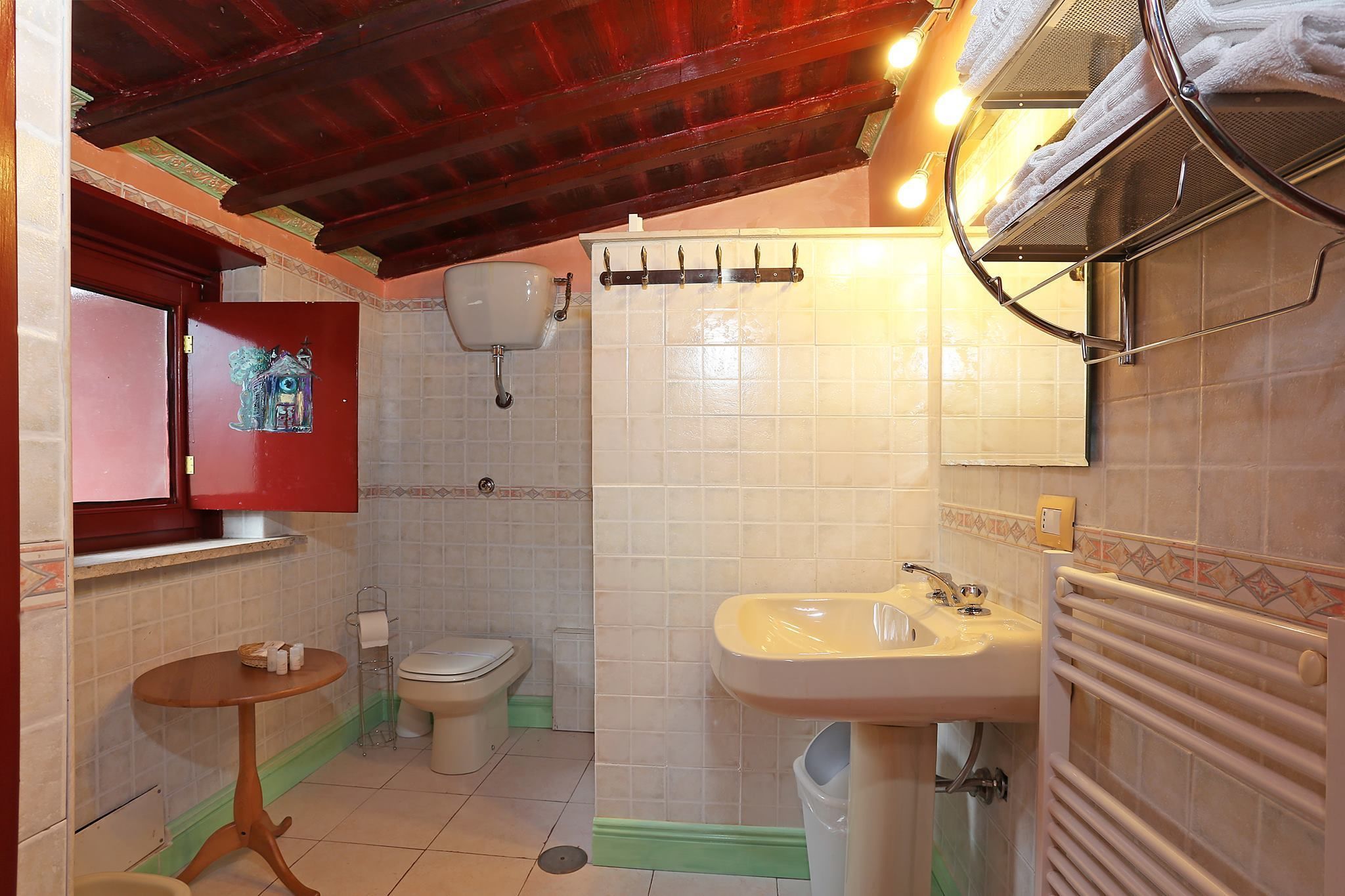 Casa de banho com lavatório, sanita e um porta-toalhas.