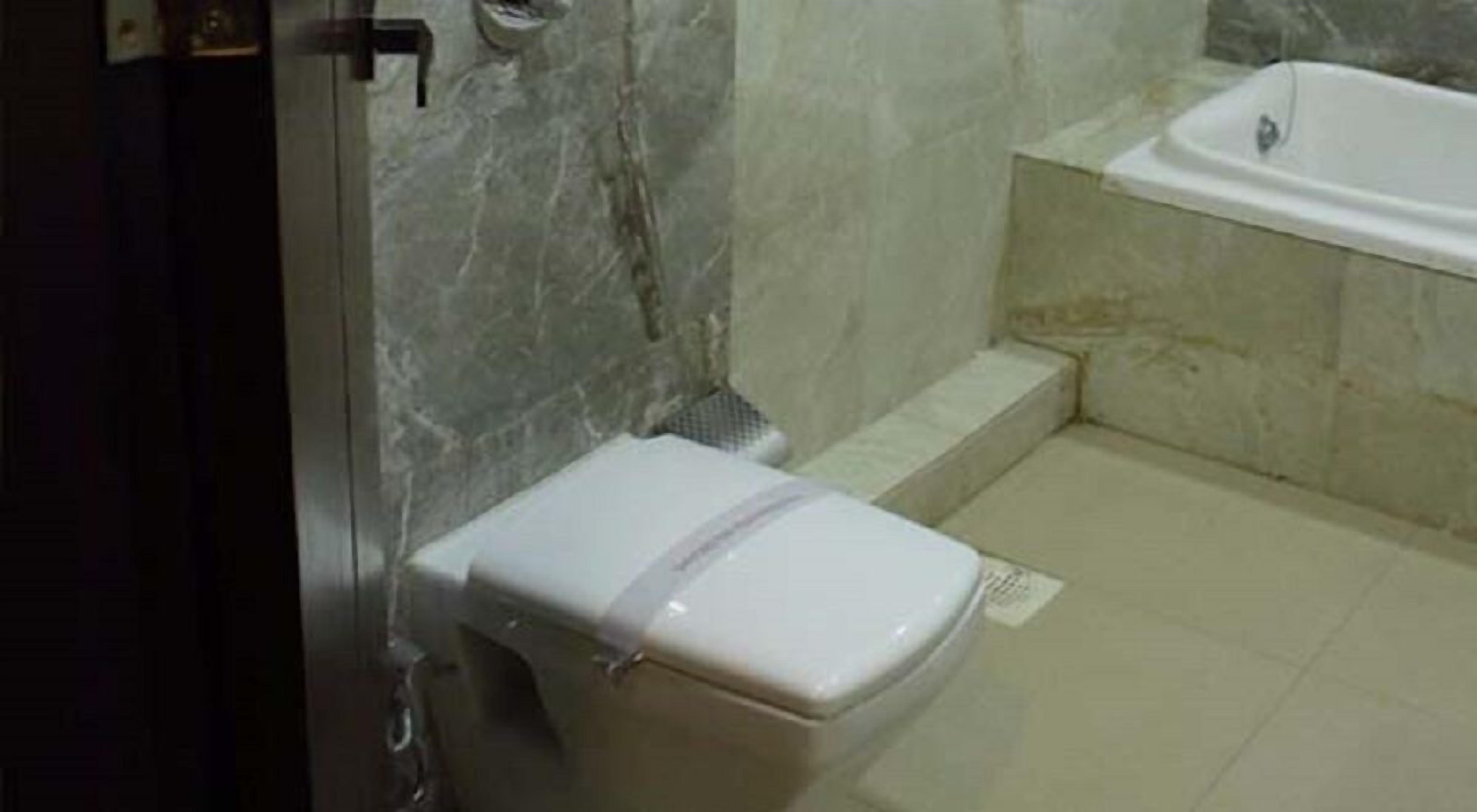 Et badeværelse med toilet, bruseniche og badekar.