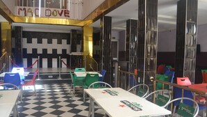 A restaurant with a checkered floor, tables with Heineken branding, and a 'Mac Dov' sign above the entrance. - Mac Dove Lounge & Suites ltd (Lagos)
