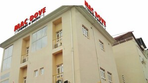 A multi-story building with signage for "MAC DOVE Lounge & Suites." - Mac Dove Lounge & Suites ltd (Lagos)