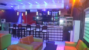 A bar area with seating and a bar counter. - Mac Dove Lounge & Suites ltd (Lagos)