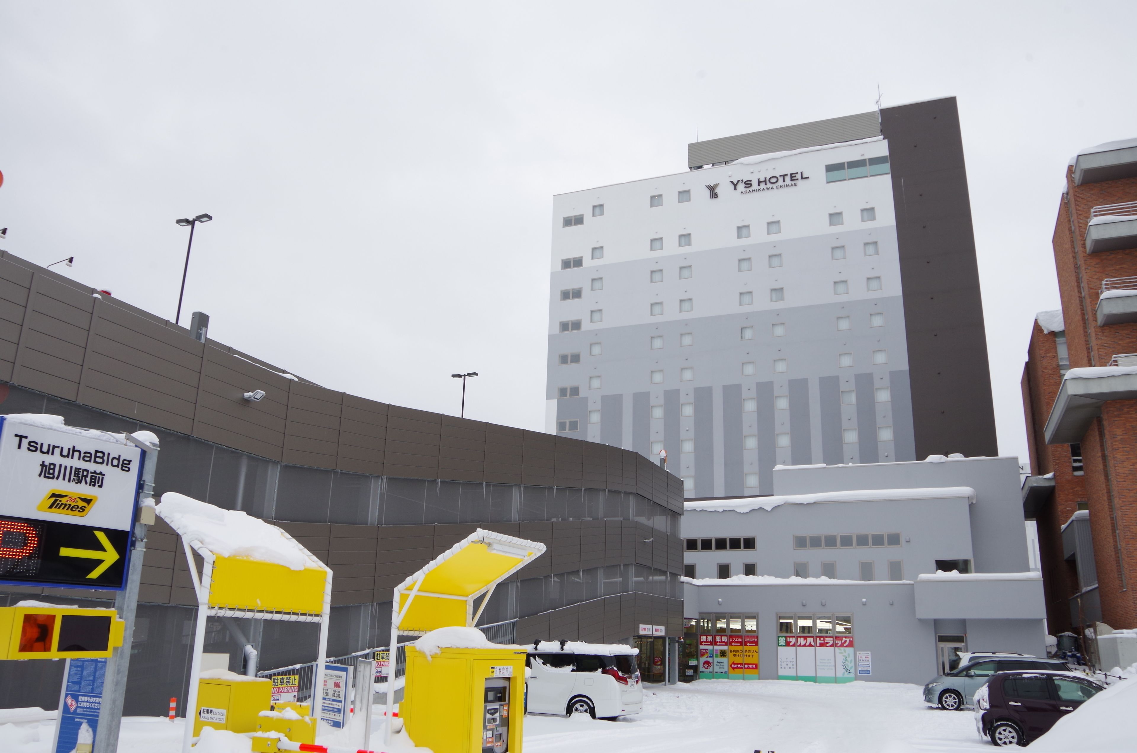 A hotel with a modern design, featuring a large number of windows and a prominent sign.