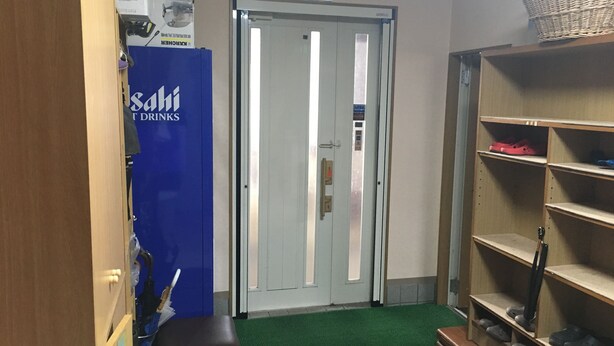 A hallway with a blue vending machine labeled "Sashi Drinks," a door with an exit sign, and shelves with shoes.