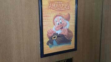 A framed picture of a cartoon character with the word "HAPPY" above it, and a plaque below with the word "HAPPY".