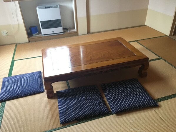 A wooden table with a matching bench in tatami mat flooring.