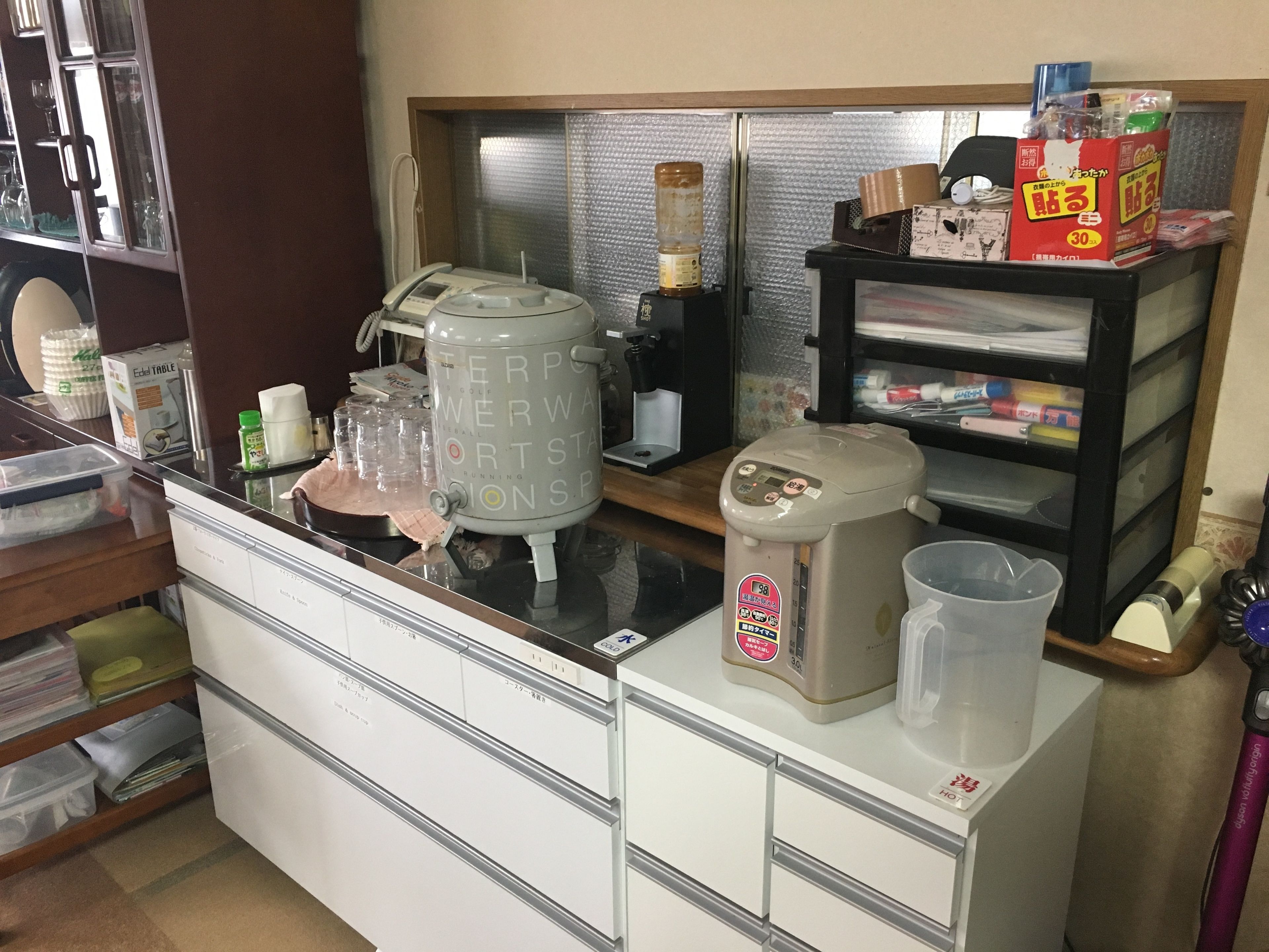 Zona cuina amb cafetera, dispensador d'aigua i nevera.
