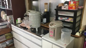 Zona cuina amb cafetera, dispensador d'aigua i nevera.