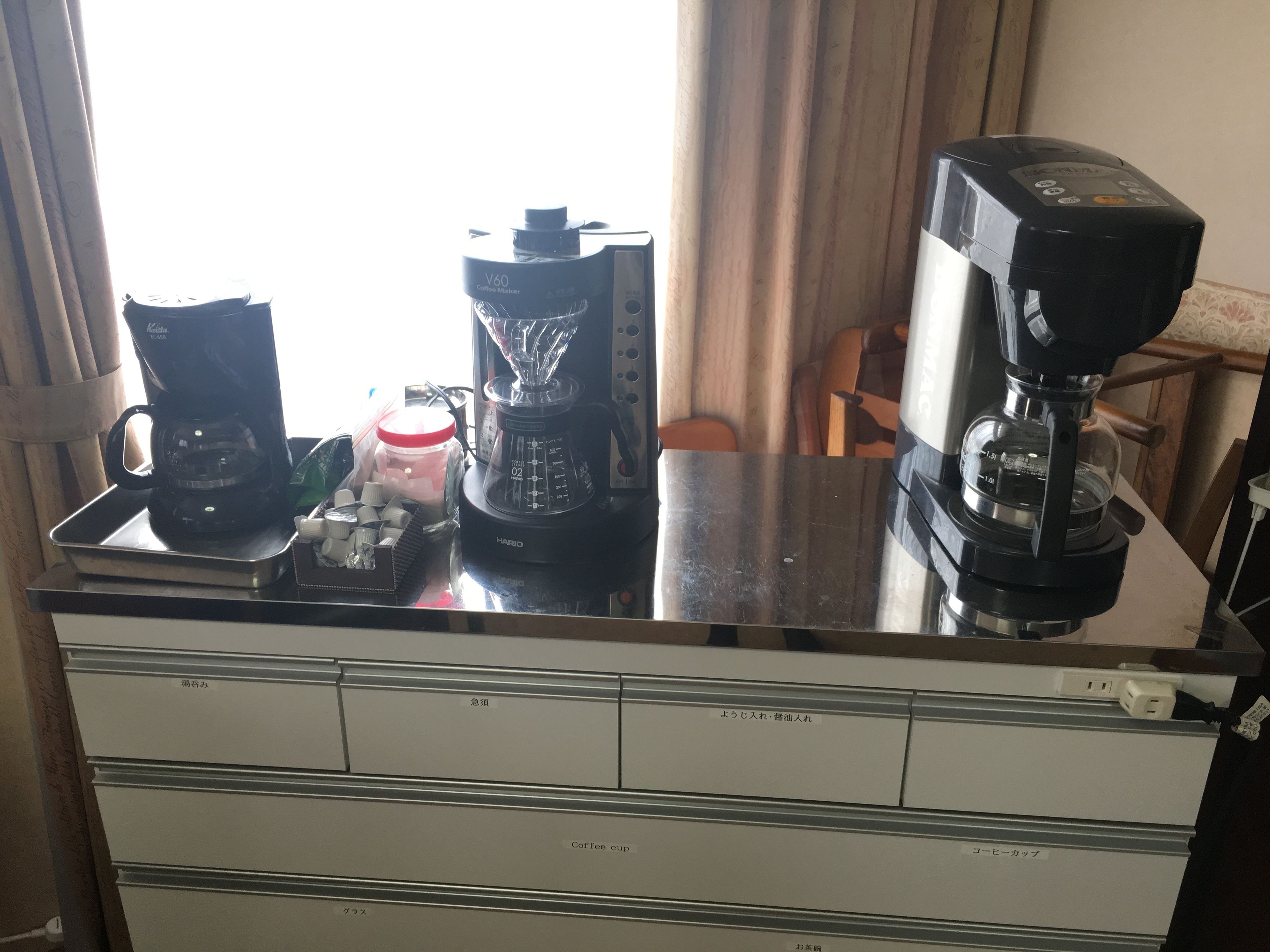 Un piano di lavoro in cucina con una macchina per il caffè, un frullatore e una tazza di caffè.