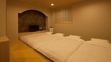 A bedroom with a large bed, a TV, and a heater.