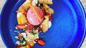Savor a sweet treat on a wooden surface, featuring a scoop of ice cream, fresh fruits, and a sprinkle of herbs.