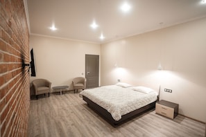 Relax in a stylish bedroom with a large bed, bedside table, and wall-mounted TV.