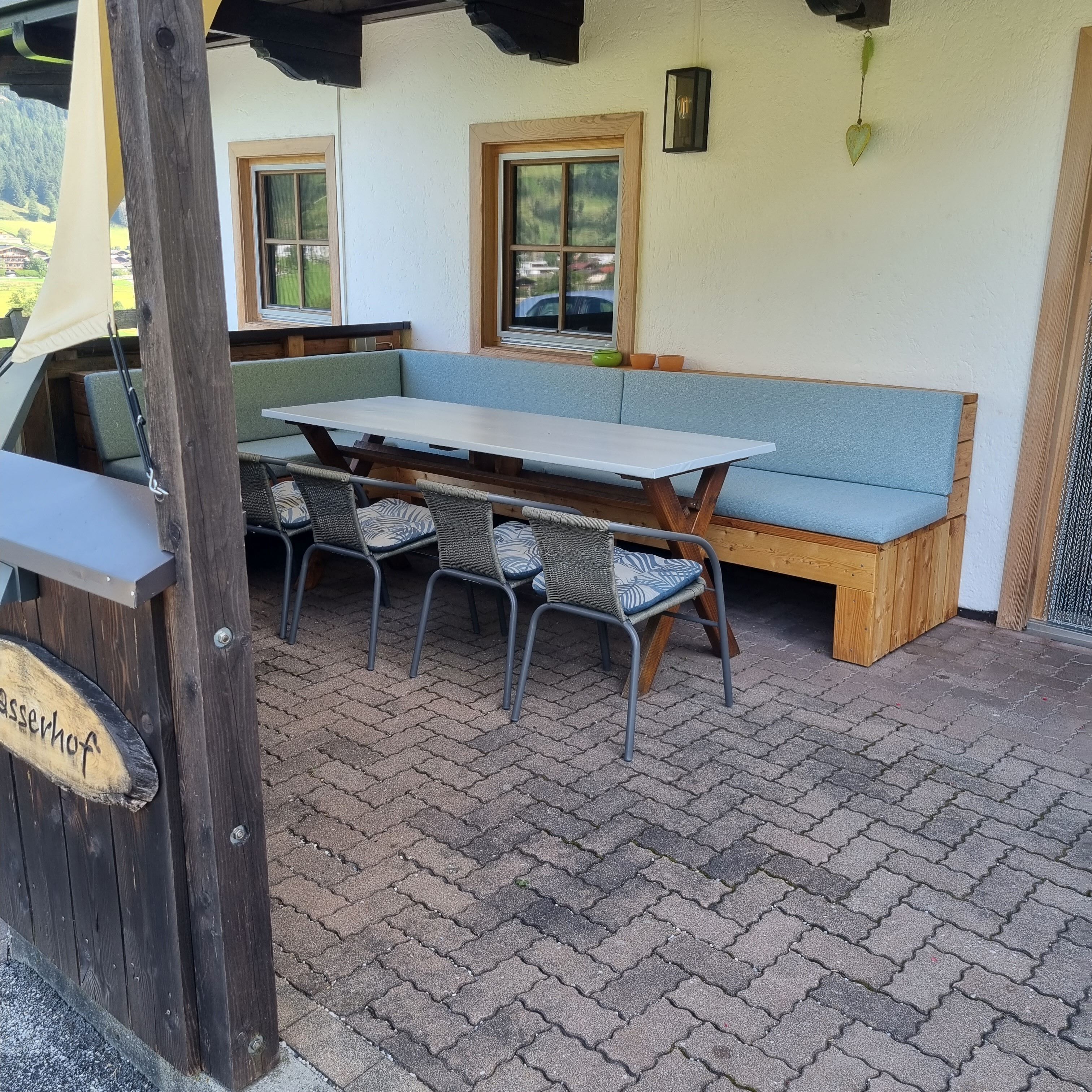 An outdoor seating area with a wooden table and chairs, a bench, and a sign reading "Restaurant".