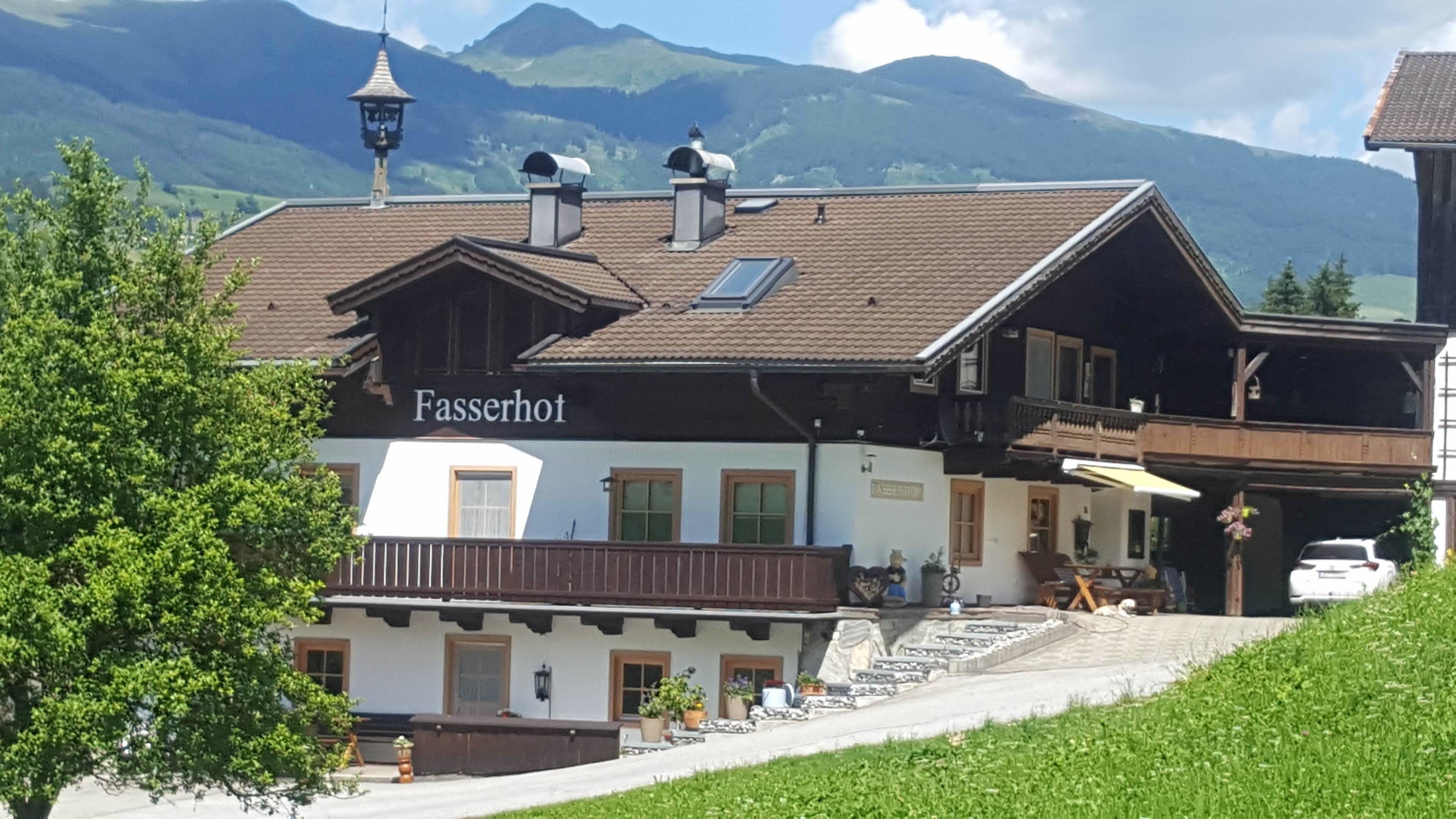 A traditional building with a sign reading "Fasserhot" and a balcony with outdoor seating.