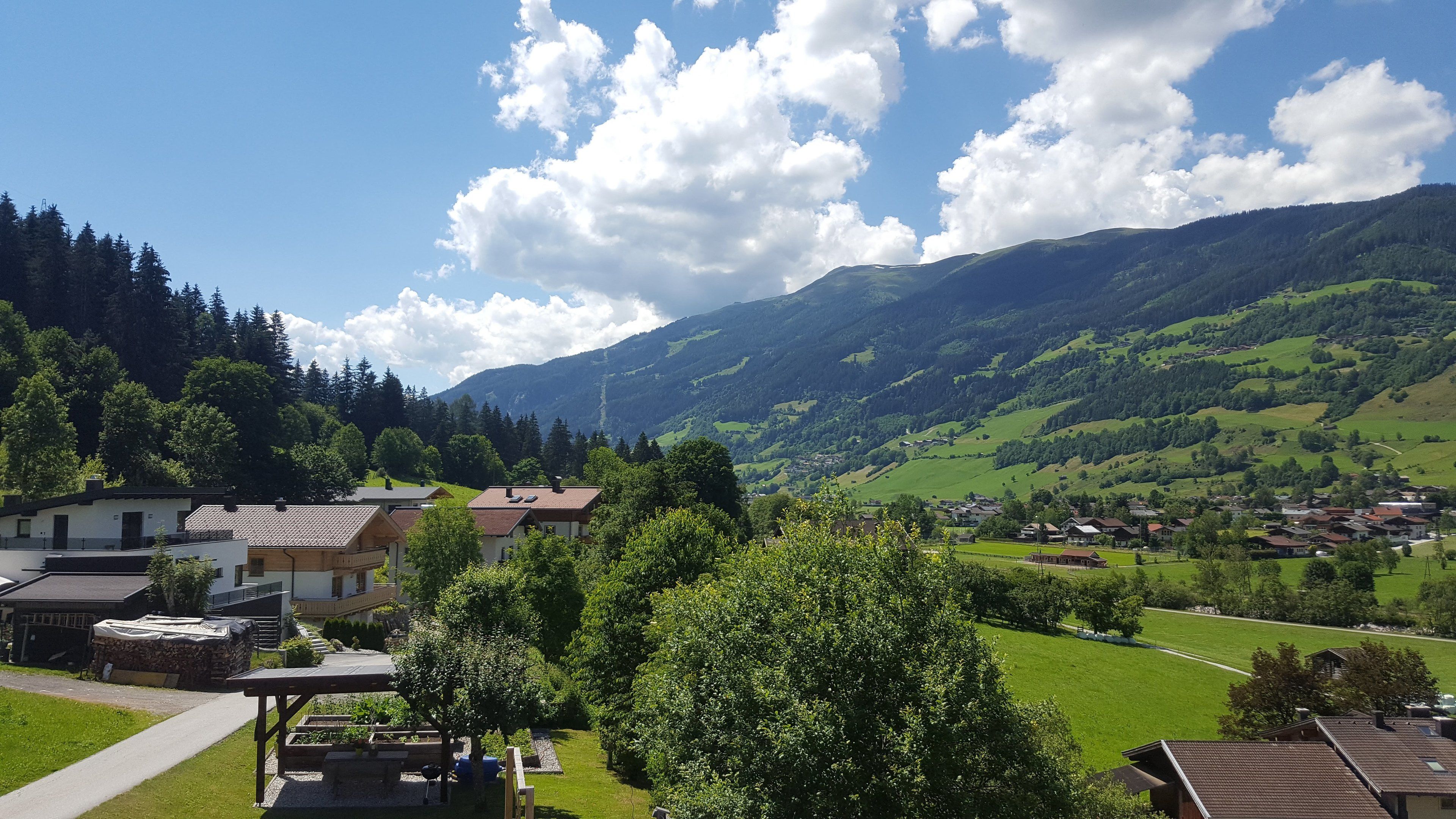 Ein ländliches Dorf mit Häusern, einem Musikpavillon und einem Berg im Hintergrund.