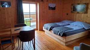 Una habitación con paneles de madera, una cama, una mesa y sillas.