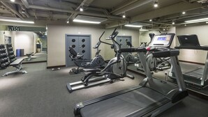 Un gimnasio con cintas de correr, elípticas y bancos de pesas.