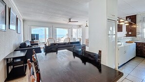 Et rummeligt køkken med spiseplads, store vinduer og havudsigt.