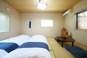 A room with two beds, a small table, and a window. - Kyo Trust (Kyoto)