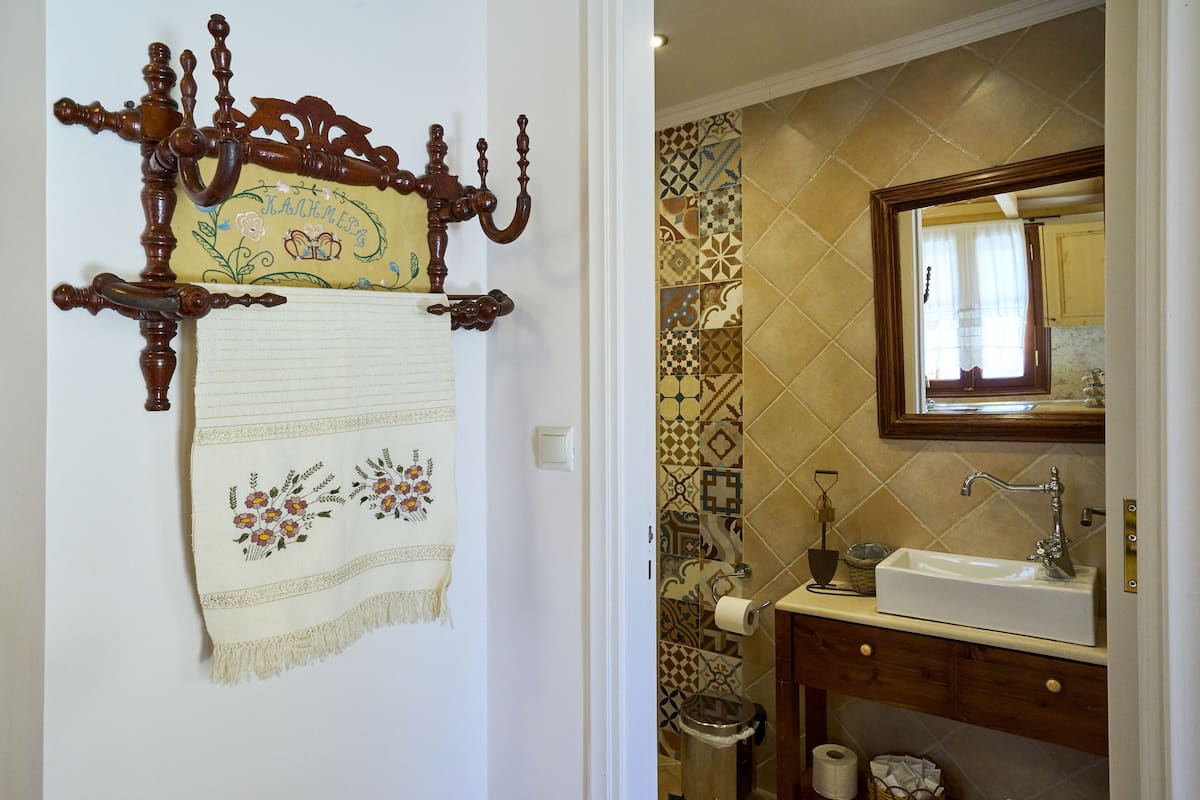 A bathroom with a sink, mirror, and patterned tiles.